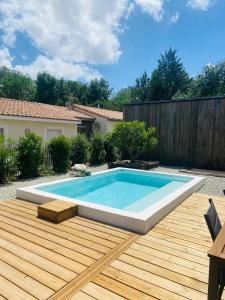 una piscina en una terraza de madera junto a una valla en Villa Gebano, en Saussines