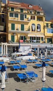 - un bouquet de chaises longues et de parasols sur une plage dans l'établissement Appartamenti sul mare Alassio, à Alassio