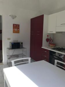 トラーパニにあるAppartamento La Cementinaの白いキャビネットと赤いドア付きのキッチン