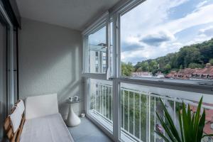 a balcony with a white chair and a large window at TAMLiving Ljubljana 2BR Center 3 Bridges Great View Kitchen in Ljubljana