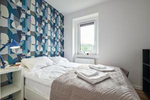 ein Schlafzimmer mit einem Bett mit einer blau-weißen Wand in der Unterkunft Blue Apartament & Office Kudowa-Zdrój in Kudowa-Zdrój