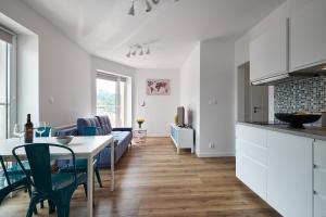 eine Küche und ein Wohnzimmer mit einem Tisch und Stühlen in der Unterkunft Blue Apartament & Office Kudowa-Zdrój in Kudowa-Zdrój