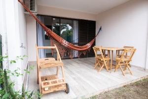 porche con hamaca, mesa y sillas en Le Privilège appartement standing, piscine, terrasse, jardin, parking privé, en Cayenne