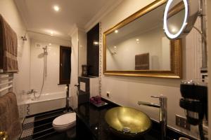 a bathroom with a sink and a toilet and a mirror at Golden Apartments in Essen