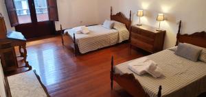 a bedroom with two beds and a dresser with two lamps at Casa Andrea in Las Palmas de Gran Canaria