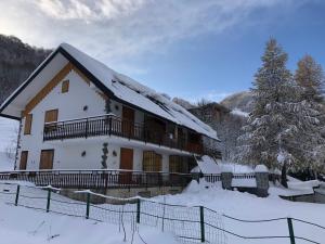 uma casa na neve com uma cerca em La Baita Limone Riserva Bianca Ski-in Ski-out Seggiovia Morel 3 em Limone Piemonte