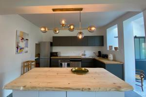 una cocina con una mesa de madera en el medio. en House with garden ideal D-DAY beaches and Caen, en Hermanville-sur-Mer
