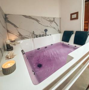 サン・ヴァレリー・シュル・ソンムにあるLa Villa Saint Valのバスルーム(紫色のバスタブ、椅子2脚付)