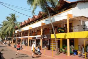 a man and woman walking down a street in front of a building at Silver Sands Sunshine - Angaara in Candolim