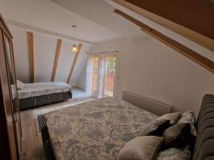 a bedroom with two beds and a couch in it at Villa Hoxha Brezovicë in Brezovica
