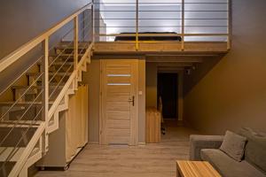 Loft con cama y escaleras en una habitación en Pensjonat Długie en Długie