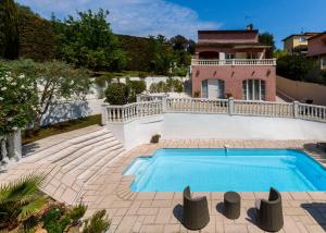 a swimming pool in front of a house at La Maisonnette du Clos in La Roquette-sur-Siagne