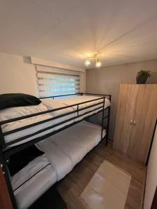 a room with two bunk beds and a window at Chalet Linée in bosrijke omgeving Anloo in Anloo