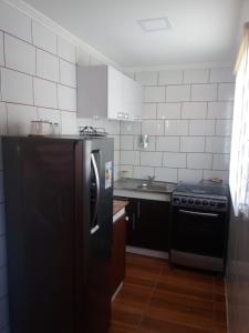 Il comprend une cuisine équipée d'un réfrigérateur noir et d'une cuisinière. dans l'établissement Sima Michi, à Puerto Natales