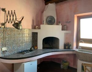 uma cozinha com um fogão e uma lareira em WUNDERGARTEN Rural Spa House em Gratteri