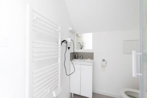 a white bathroom with a shower and a sink at Glm Residences 1 in Saint-Quentin