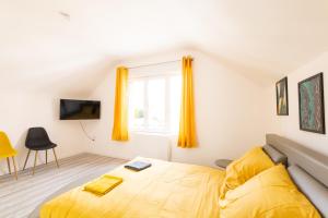 a bedroom with a yellow bed and a window at Glm Residences 1 in Saint-Quentin