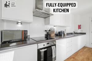 cocina con armarios blancos y microondas en Lux Penthouse Flat in Stevenage with Balcony, Super King Bed & Fast WiFi en Stevenage
