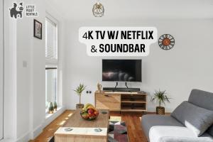 a living room with a couch and a tv at Lux Penthouse Flat in Stevenage with Balcony, Super King Bed & Fast WiFi in Stevenage