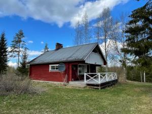a red house with a porch in a field at Villa Mushroom in Vuoriniemi