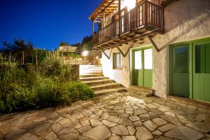 dom z zielonymi drzwiami i balkonem w obiekcie Olea Skopelos villas with swimming pools & sea view w mieście Panormos
