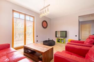 uma sala de estar com dois sofás vermelhos e uma mesa em PATEK Premium Apartments - Airport & MTP em Skórzewo
