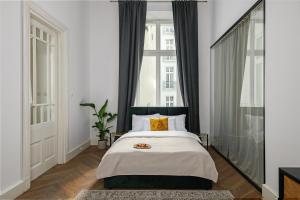 sypialnia z łóżkiem i dużym oknem w obiekcie oompH Koszyki Luxurious Apartments w Warszawie