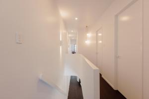 a hallway with white walls and a white staircase at NEW! Dacha on Maggie No#2, Unrivaled Island Luxury in Nelly Bay