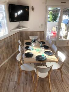 uma mesa de jantar com cadeiras e uma televisão na parede em Appartement lumineux avec grande terrasse em Clermont-Ferrand