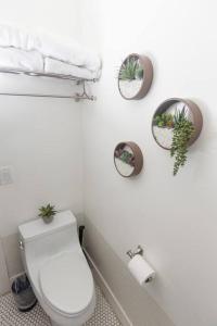 a bathroom with a toilet and plants on the wall at Mid Century Modern - Walk to Dodger Stadium, DTLA in Los Angeles