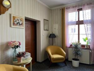 Habitación con silla, mesa y ventana en Hotel i Restauracja Castle, en Bystrzyca Kłodzka