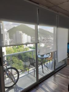 a room with a balcony with a bike in the window at DFC Salta Estudio 2p in Salta