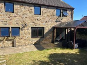 a brick house with an awning in front of it at Central House 5 Bedroom Luxury Stone Built House 