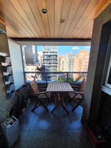 a balcony with a table and chairs and a view of a city at LOCADOR Nueva Cordoba 10A in Cordoba