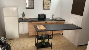 a kitchen with a counter with a sink and a refrigerator at Sarah Kite II Vv, room 3 in Playa del Burrero