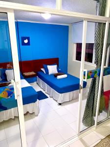 a blue room with two beds and a mirror at Apartment Angeluz in San Andrés