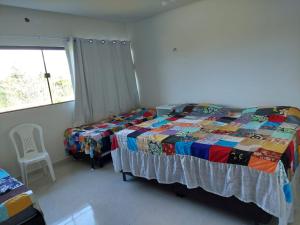 ein Schlafzimmer mit einem Bett und einem Stuhl und einem Fenster in der Unterkunft Casa com 3 quartos em Condomínio de Luxo in Gravatá + 16 Fotos