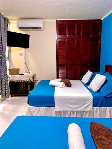 duas camas num quarto com azul e branco em Apartment Angeluz em San Andrés