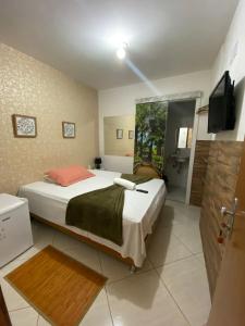 Un dormitorio con una cama grande y un televisor. en Pousada Bahia Morena, en Salvador