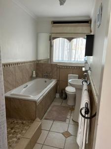 ein Badezimmer mit einer Badewanne, einem WC und einem Waschbecken in der Unterkunft Silken Trap Accommodation NO LOADSHEDDING in Johannesburg