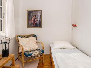 ファーンにあるHoliday home Fanø VIIの小さなベッドルーム(ベッド1台、椅子付)