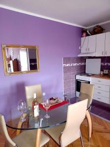 una cocina con una mesa de cristal con copas de vino. en Lovely L home BN centar -Rent a car automatic, en Bijeljina