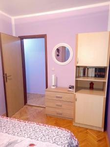 1 dormitorio con cama, tocador y espejo en Lovely L home BN centar -Rent a car automatic, en Bijeljina