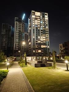 a park at night with tall buildings in a city at Luxury Stay in Sheikh Zayed