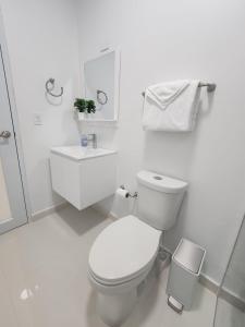 La salle de bains blanche est pourvue de toilettes et d'un lavabo. dans l'établissement Home San Juan, à San Juan