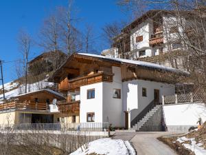 a house in the mountains with snow on the ground at Apartment Schragl in Zell am Ziller
