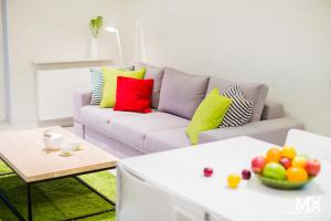 ヴロツワフにあるMojito Apartments – Botanicaのリビングルーム(カラフルな枕とソファ付)