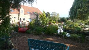 un giardino con panchina di fronte a una casa di Holiday home L'Aubépine a Tournai
