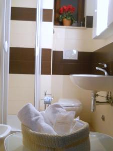 a bathroom with a towel basket and a sink at B&B Lucana 22 in Matera