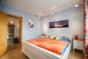 ein Schlafzimmer mit einem Bett mit einer orangefarbenen Decke in der Unterkunft Meerforelle 207 - Villa Seeblick in Sassnitz